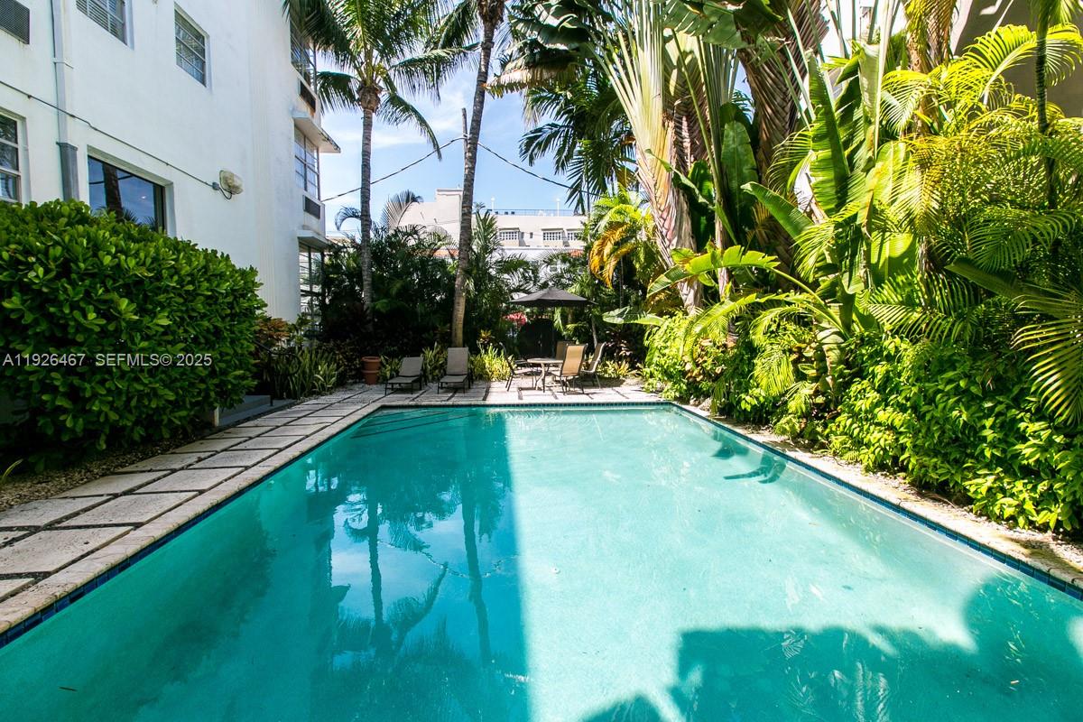 420 15th Street, Unit 106 Miami Beach, FL 33139 - Photo 9 of 9 a view of a swimming pool with a bench and lawn chairs