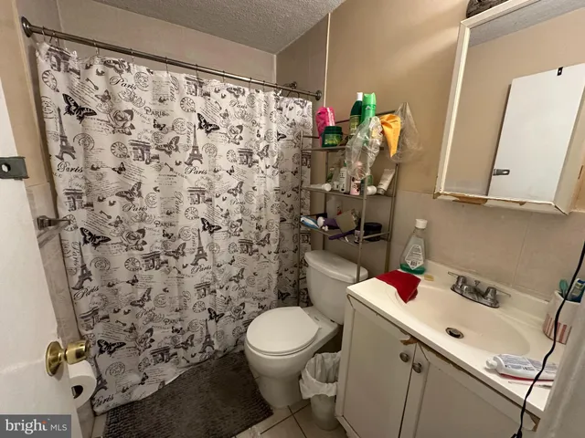 a bathroom with a toilet sink and shower curtain
