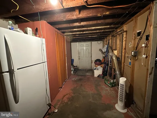a view of a storage and utility room with refrigerator