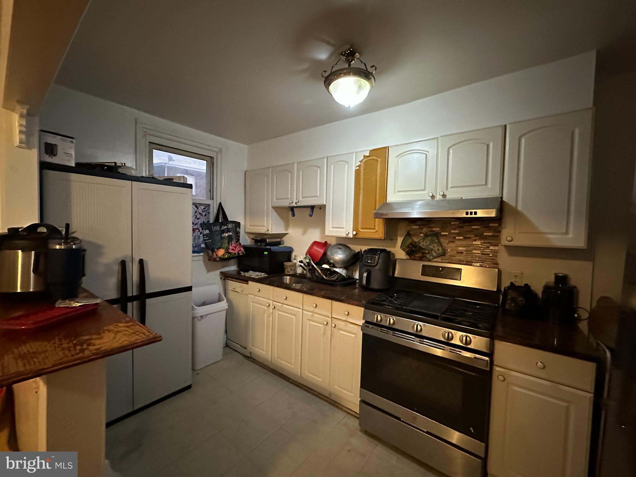 7143 Jackson Street Philadelphia, PA 19135 - Photo 8 of 23 a kitchen with stainless steel appliances granite countertop a refrigerator stove and sink