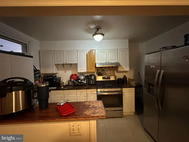 a kitchen with stainless steel appliances granite countertop a refrigerator sink stove and cabinets