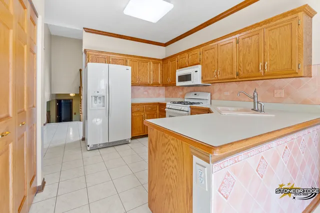 a kitchen with stainless steel appliances a stove a refrigerator a sink a counter space and cabinets