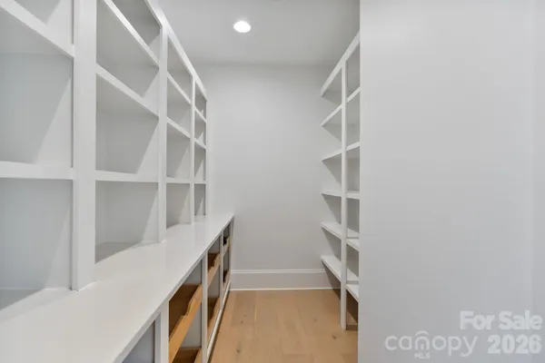 a living room with furniture cabinets and a large window