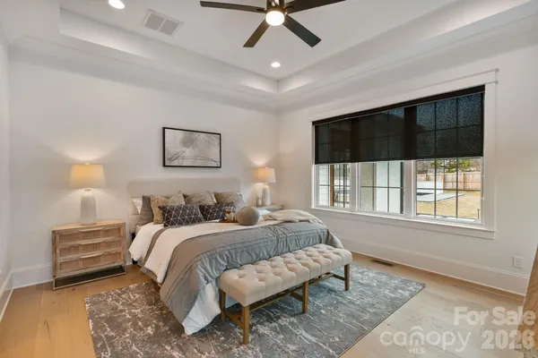 a view of a livingroom with a chandelier curtains and wooden floor