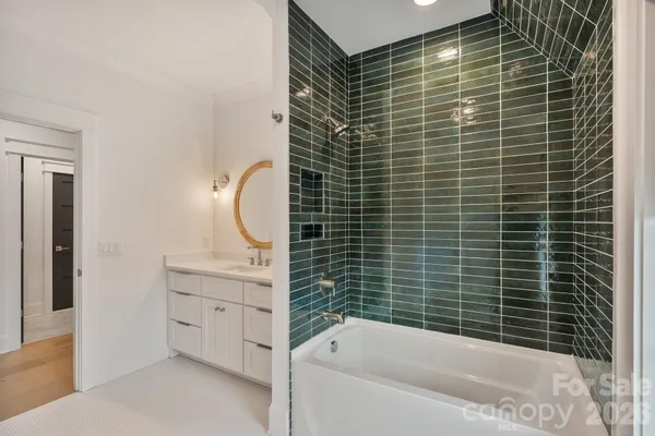 a bathroom with a tub sink and mirror