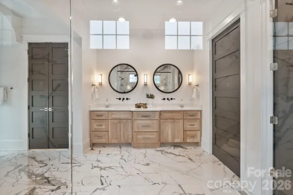a bathroom with a double vanity sink mirror and shower