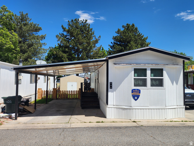 332 Joshua Street Tooele, UT 84074 - Photo 1 of 16 White exterior with black trim, featuring a covered carport
