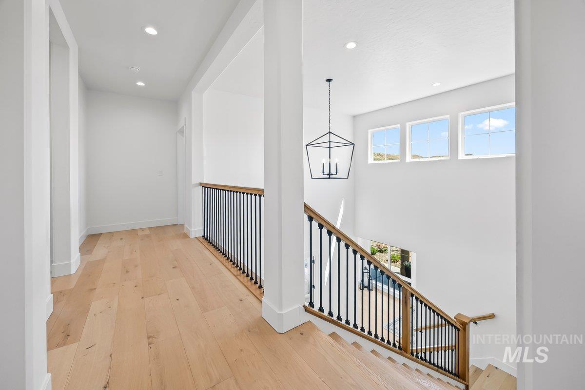 13746 North Ruffed Grouse Way Boise, ID 83714 - Photo 21 of 43 Hallway featuring a chandelier, an upstairs landing, recessed lighting, and hardwood / wood-style floors