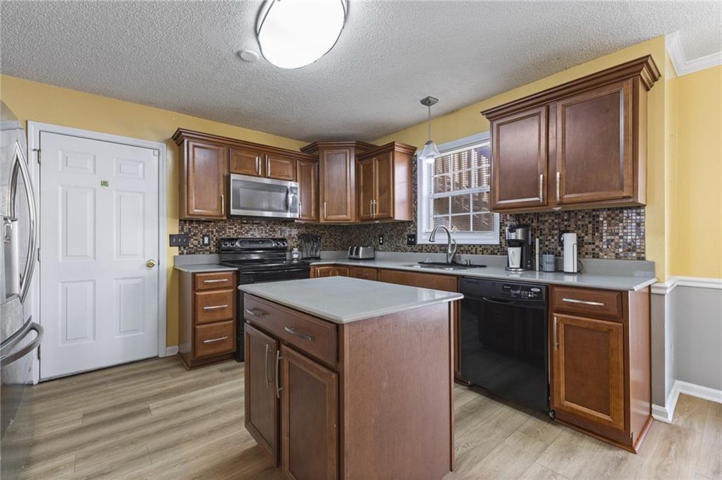 4008 Lindsey Lane Rex, GA 30273 - Photo 12 of 34 a kitchen with stainless steel appliances granite countertop a stove a sink dishwasher and a microwave oven with wooden floor