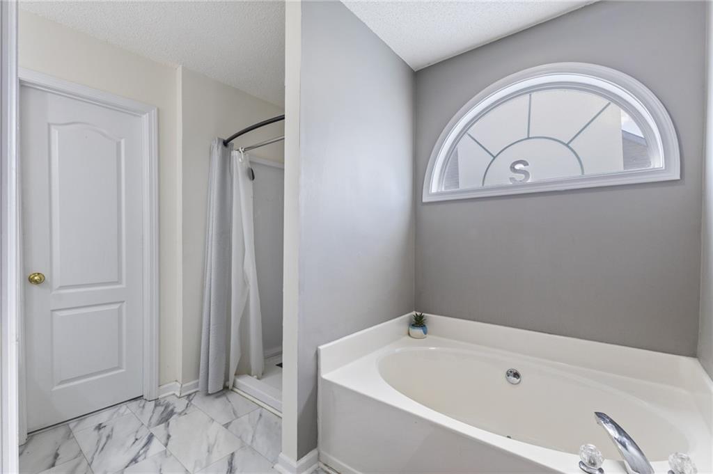 4008 Lindsey Lane Rex, GA 30273 - Photo 27 of 34 a bathroom with a bathtub and a window