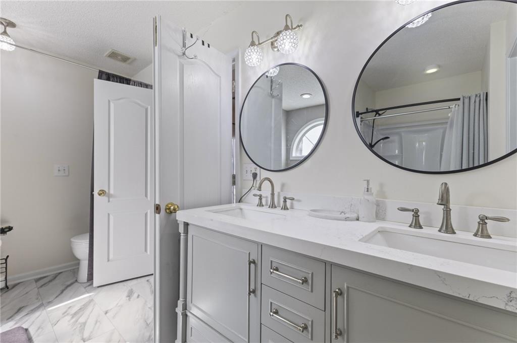 4008 Lindsey Lane Rex, GA 30273 - Photo 28 of 34 a bathroom with a double vanity sink and a mirror