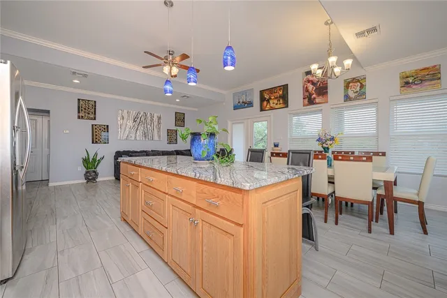 a kitchen with granite countertop a dining table chairs sink and cabinets