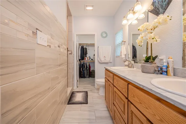 a spacious bathroom with a double vanity sink a mirror and shower