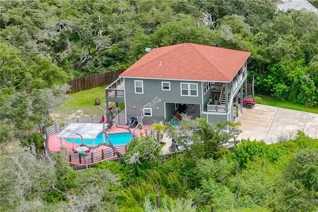 an aerial view of a house roof deck with table and chairs plants with large trees