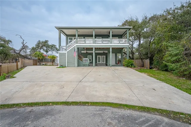 a front view of a house with a yard and potted plants