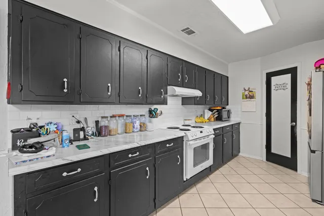 a kitchen with a sink stove top oven and cabinets
