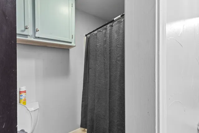 a bedroom with a bed gym equipment and view of living room