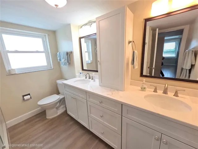 a bathroom with a double vanity sink a toilet and a mirror