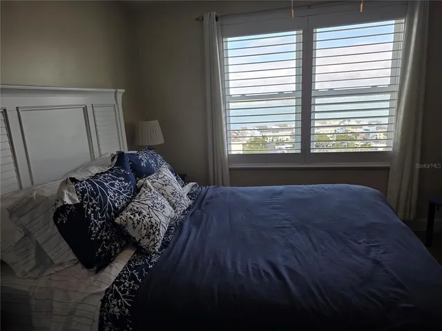 a bed sitting in a bedroom next to a window