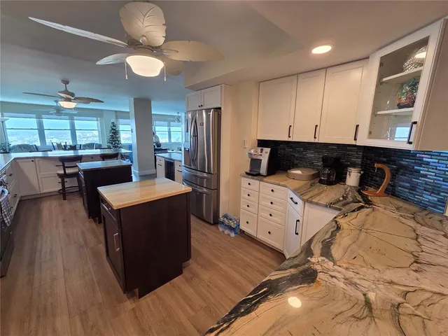 a kitchen with a stove a refrigerator and a stove with wooden floors