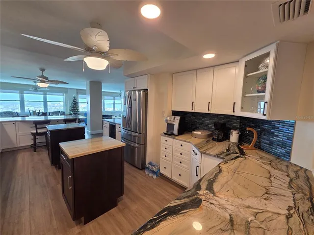 a kitchen with granite countertop a stove a sink and a refrigerator