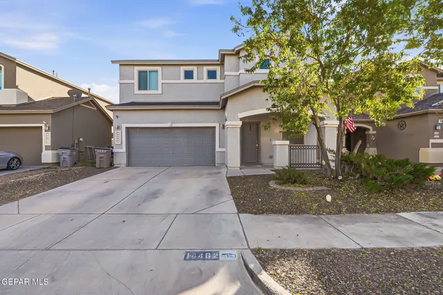 a front view of a house with yard and garage