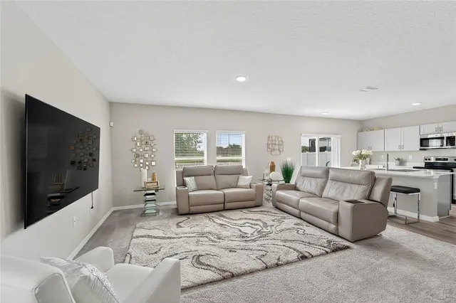 a kitchen with a refrigerator a stove a sink cabinets and wooden floor