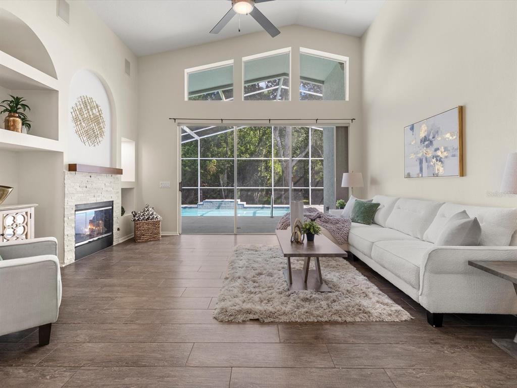 7935 Calindra Court Trinity, FL 34655 - Photo 16 of 52 a living room with furniture large window and a fireplace