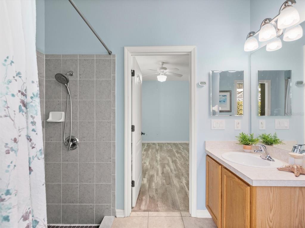 7935 Calindra Court Trinity, FL 34655 - Photo 29 of 52 a bathroom with a granite countertop sink a mirror and shower