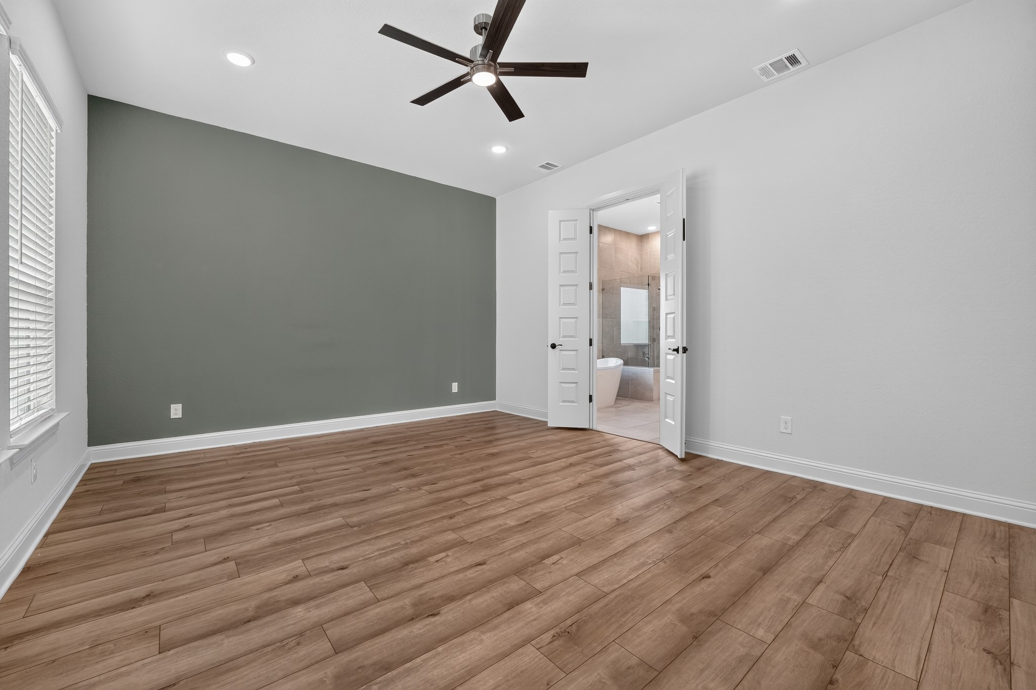 508 Pinnacle View Drive Georgetown, TX 78628 - Photo 9 of 27 A spacious bedroom with rich hardwood-style flooring and direct access to a private bathroom retreat.