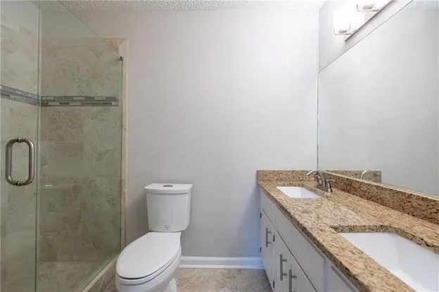 a bathroom with a granite countertop sink toilet and shower