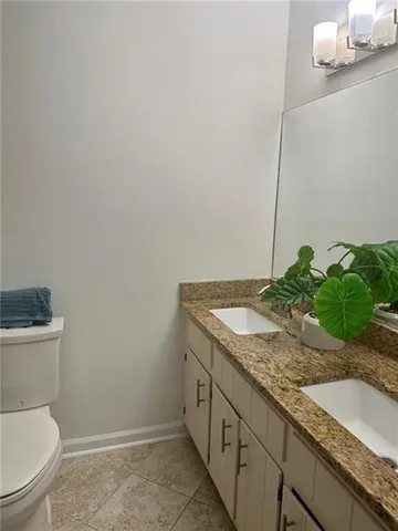 a bathroom with a granite countertop sink and toilet