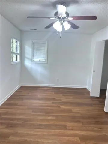 a view of a room with wooden floor and ceiling fan
