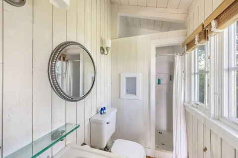 a bathroom with a toilet a sink and a mirror