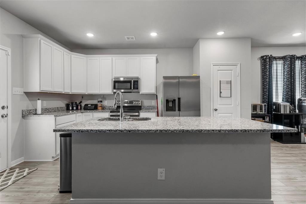 3525 Beutel Road Lorena, TX 76655 - Photo 7 of 34 a kitchen with kitchen island granite countertop a sink a stove and cabinets