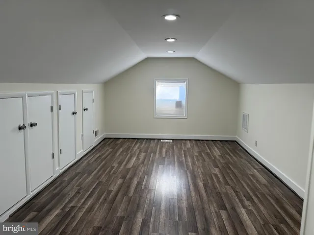 a view of a room with wooden floors and window