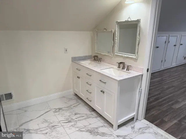 a bathroom with a double vanity sink and a mirror