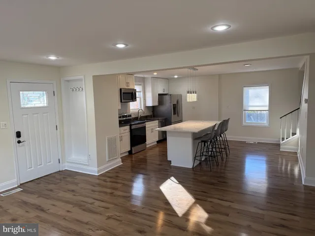 a view of a dining room with furniture a rug and wooden floor