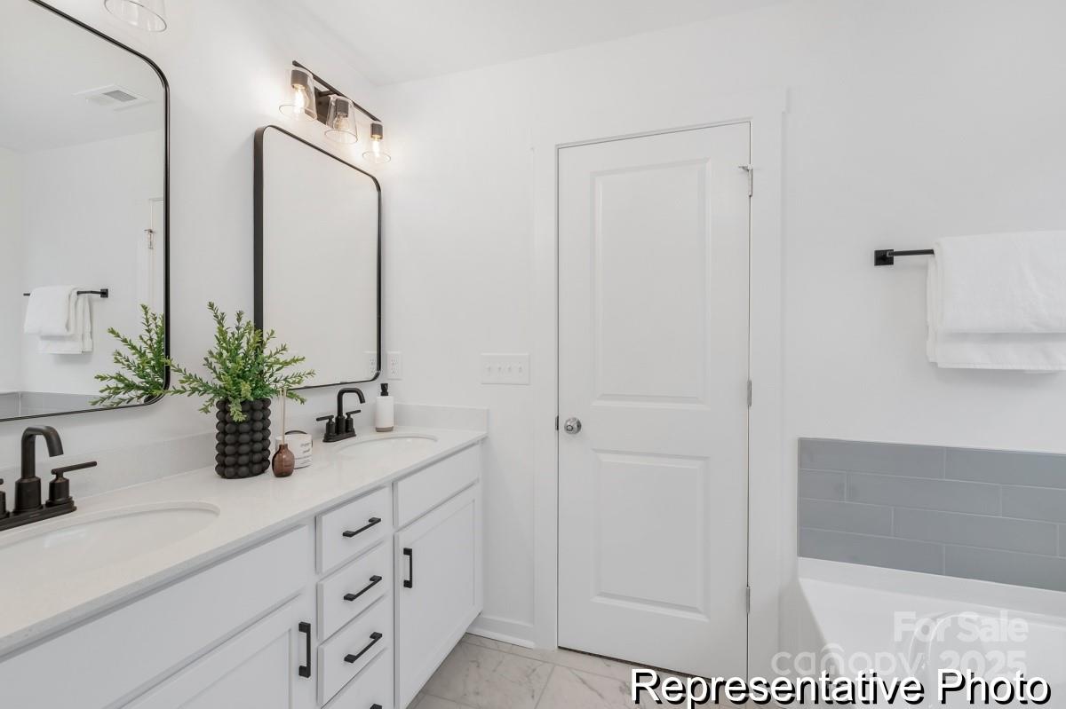 128 Peak Vw Road, Unit 5P Statesville, NC 28677 - Photo 14 of 28 a bathroom with a double vanity sink a mirror and a shower