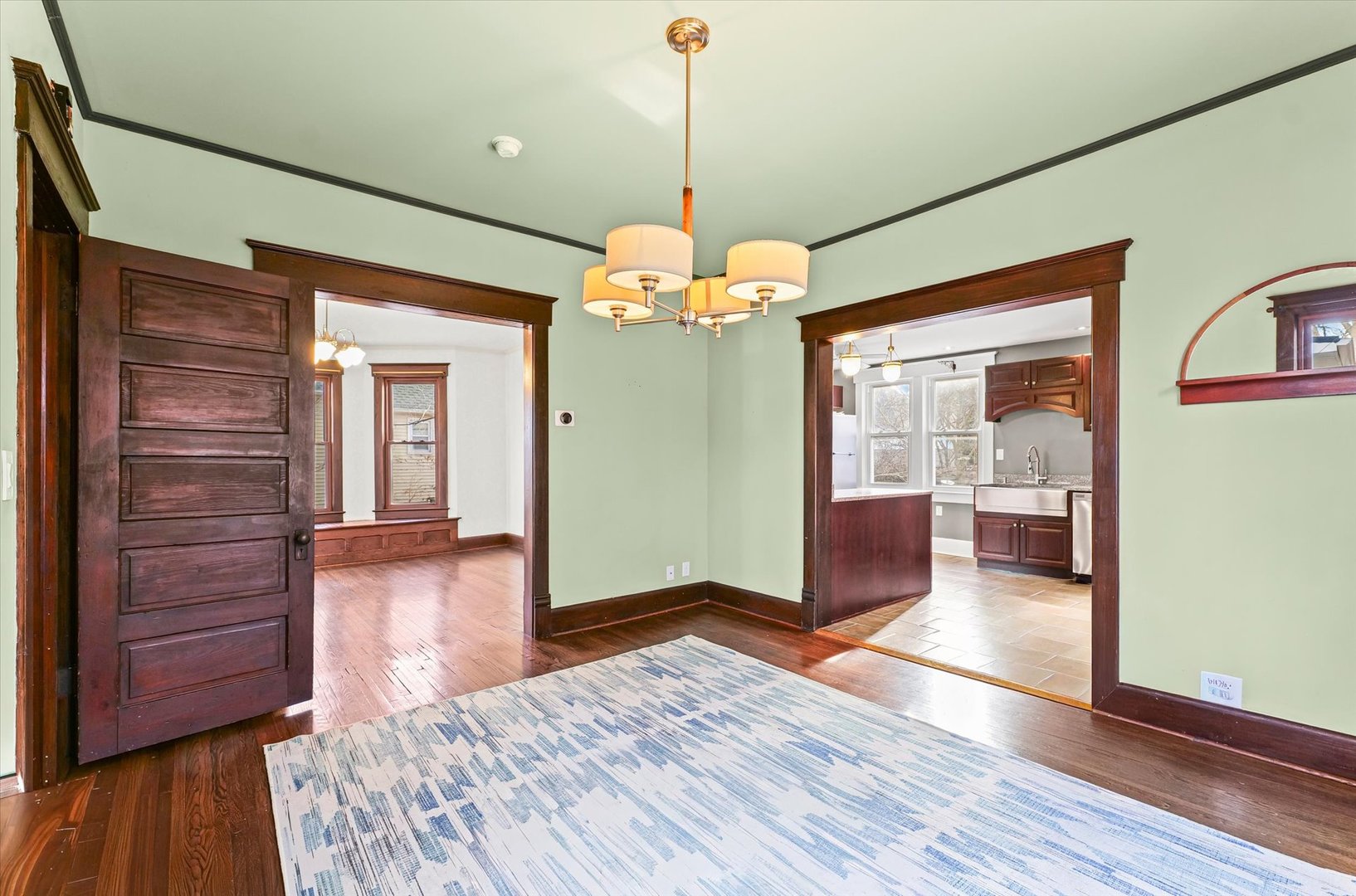 407 West High Street Urbana, IL 61801 - Photo 8 of 28 a view of a room with wooden floor staircase and a kitchen