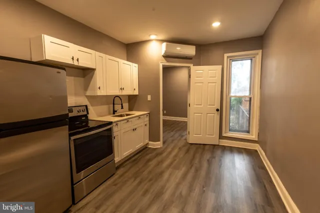 a kitchen with granite countertop a refrigerator and wooden floor