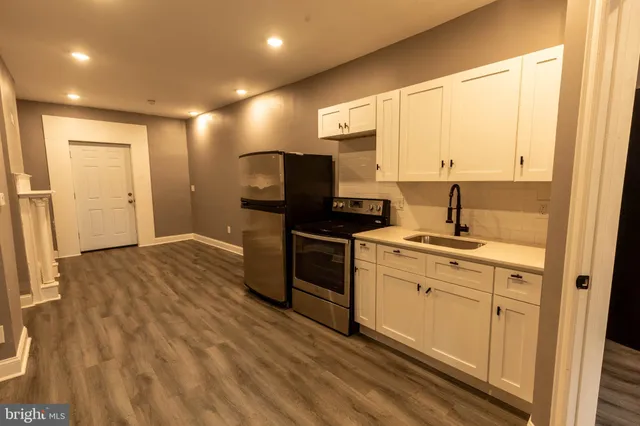 a kitchen with a sink cabinets and wooden floor