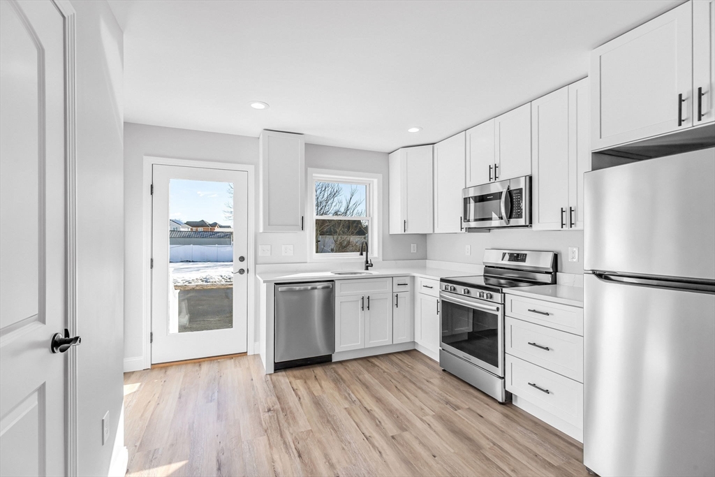 a kitchen with white cabinets stainless steel appliances and sink