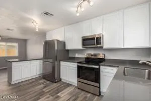 a kitchen with stainless steel appliances granite countertop a stove a refrigerator and a microwave