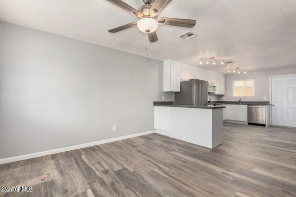 a view of kitchen with refrigerator microwave and wooden floor