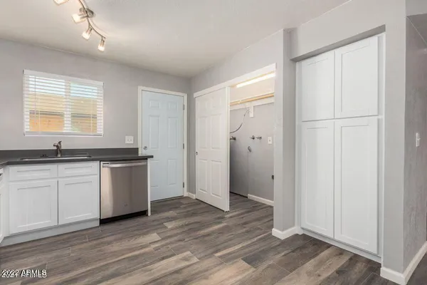 a view of a kitchen with a sink and dishwasher wooden floor