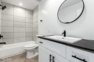 a bathroom with a granite countertop toilet sink and mirror