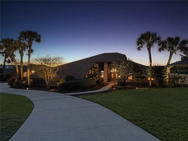 a kitchen with stainless steel appliances granite countertop a stove top oven a sink dishwasher and a refrigerator with wooden cabinets