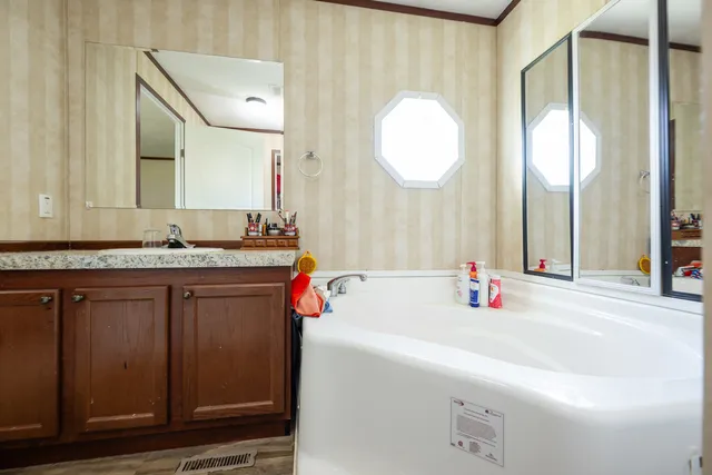 a bathroom with a tub sink and mirror