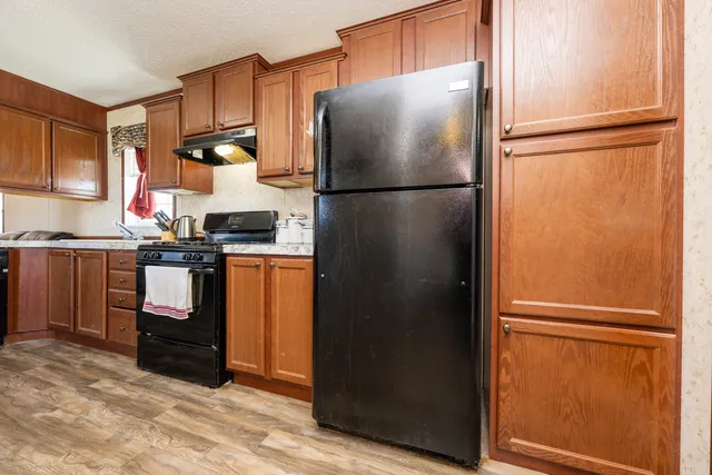 a kitchen with stainless steel appliances granite countertop a refrigerator and a sink